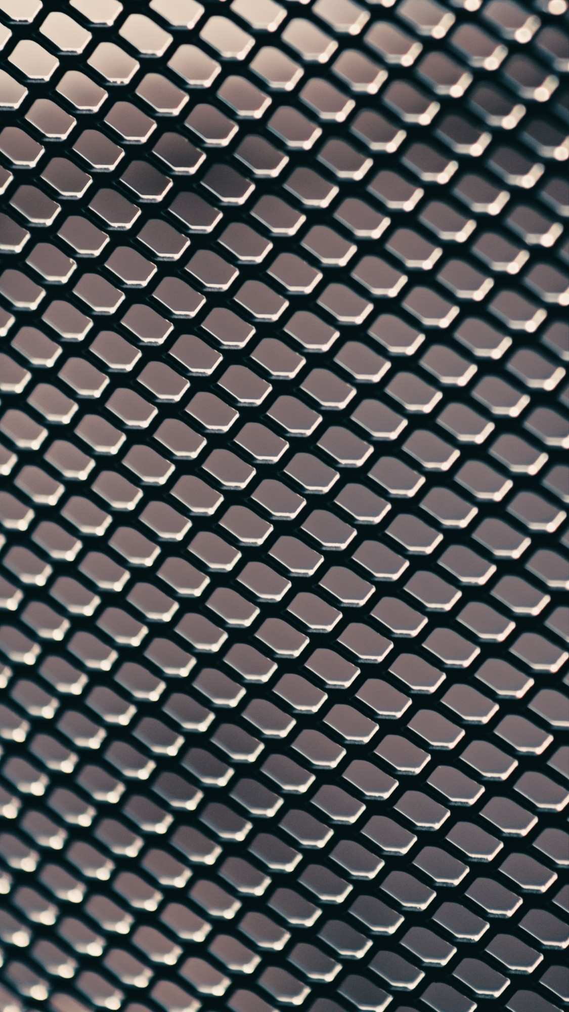 Close-up macro texture view of a durable black metal wire mesh screen grid barrier