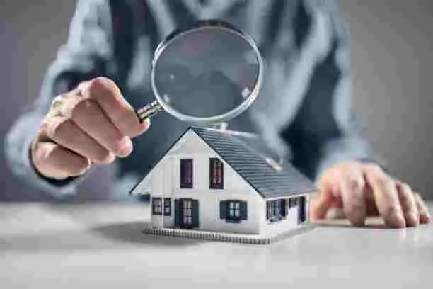Pest Control Solutions with a professional inspecting a model house using a magnifying glass